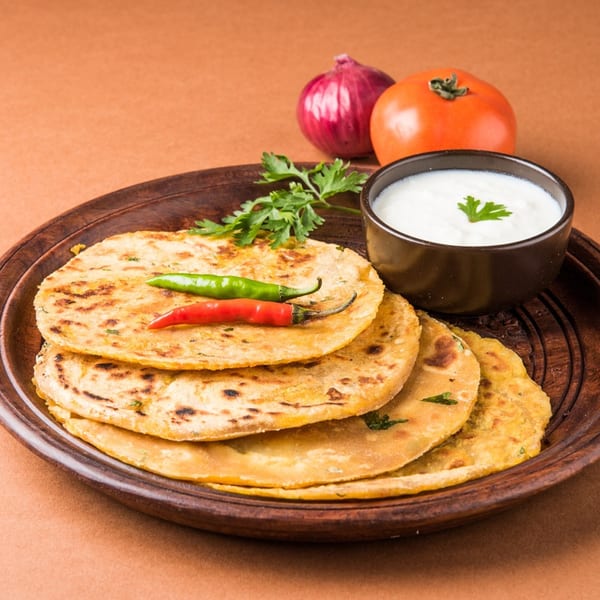 Indian paratha flatbreads with green and red chilies, cilantro, yogurt, onion, and tomato.